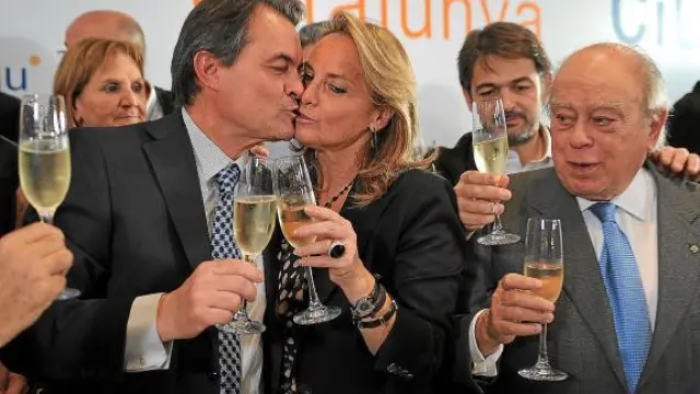 Artur Mas besa a su esposa en presencia de Jordi Pujol en la celebración del triunfo electoral.