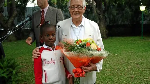 Carmen Acín, con el embajador español detrás, y junto a una mozambiqueña, el día que fue premiada.
