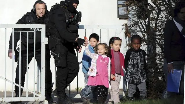Policías acompañan a varios niños de un colegio de Besançon, en Francia, donde acabó felizmente el secuestro de una clase