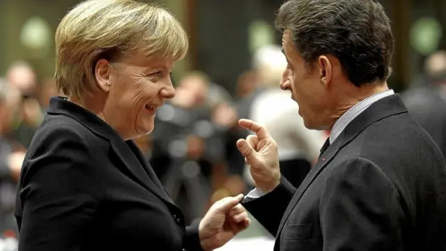 La canciller alemana, Angela Merkel, conversa con el presidente francés, Nicolas Sarkozy, ayer en Bruselas.