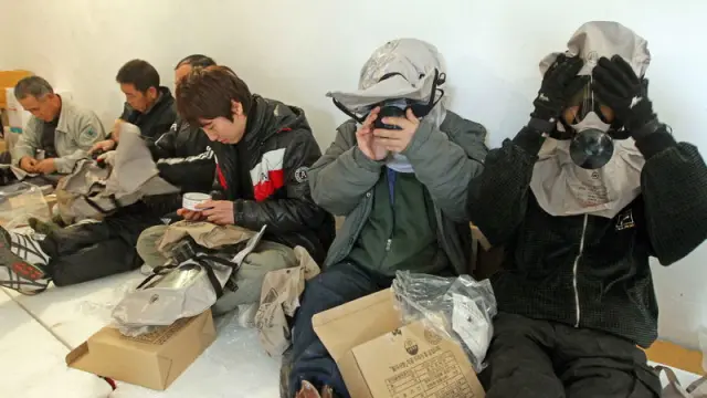 Varias personas se ponen máscaras antigas en el interior de un refugio en la Isla Yeonpyeong