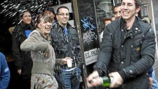 Varios jóvenes celebran su suerte con champán, en Madrid.