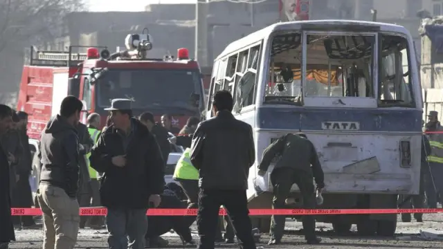 Agentes de seguridad inspeccionan el furgón que fue atacado hoy en Kabul