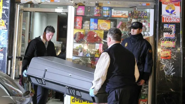 Miembros de la funeraria retiran el cuerpo de la mujer del establecimiento en el que trabajaba