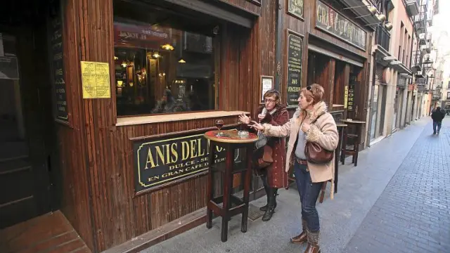 Dos clientes utilizan las mesas colocadas a las puertas de una céntrica cafetería para tomar una consumición sin dejar de fumar.