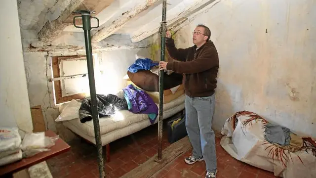 David Ruiz apuntala el techo de la casa que ocupa desde hace un año en el barrio Cuevas del Siete. No tiene agua ni luz eléctrica.