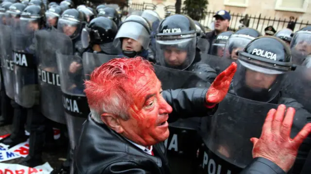 Un manifestante herido junto a la policía.