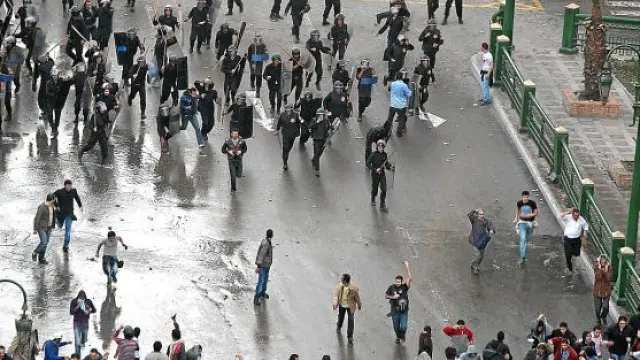 Policías antidisturbios se enfrentan a decenas de personas, ayer en el centro de El Cairo.