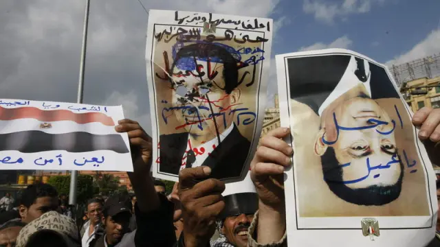 Manifestantes portan retratos de Mubarak modificados