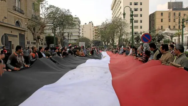 Manifestantes contra Mubarak sostienen una bandera egipcia gigante mientras se concentran en la calle del Parlamento, en El Cairo.