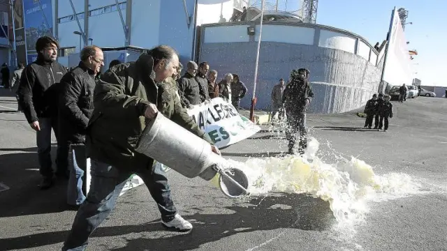Fernando Luna, presidente provincial de Asaja en Huesca, arroja el contenido de una lechera junto al estadio del Alcoraz.