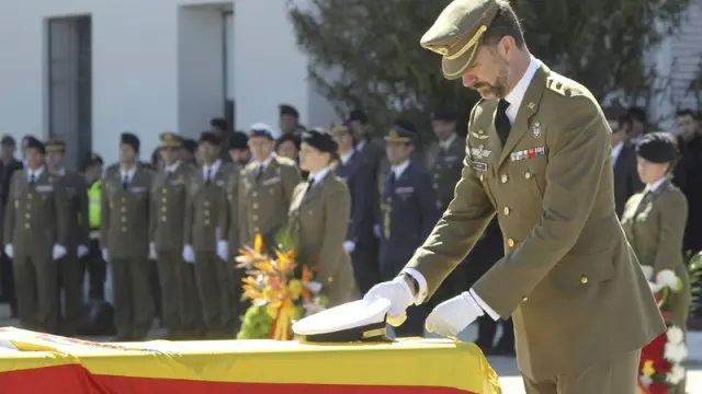 El príncipe de Asturias coloca la Cruz del Mérito Militar con distintivo amarillo en uno de los féretros de los cinco militares muertos el pasado jueves