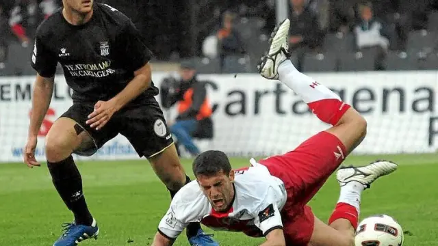 El delantero del Huesca Roberto García cae al suelo ante la presencia de un futbolista del Cartagena.