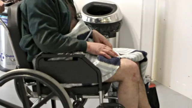 J.M.B. de 52 años, uno de los rescatados, es conducido en silla de ruedas en el hospital de Cruces