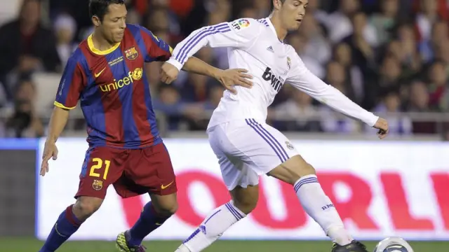 Cristiano Ronaldo controla un balón frente al defensa brasileño Adriano.