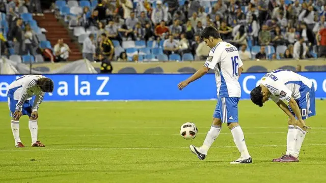 Ponzio y Bertolo se lamentan mirando al suelo, mientras Braulio se dispone a sacar de centro tras recibir el tercer gol de Osasuna.