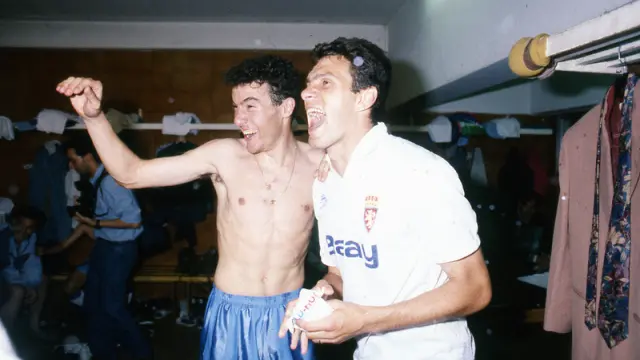 Xavi Aguado celebra la victoria en el vestuario junto a Gustavo Poyet.