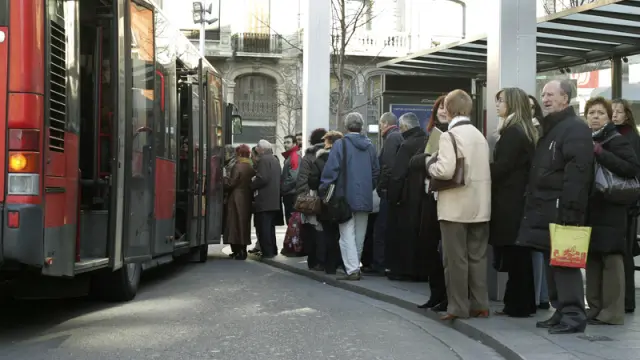 Imagen de viajeros esperando en una parada de autobús de Zaragoza.