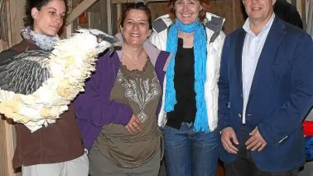 Una voluntaria de la FCQ con un señuelo que utilizan para alimentar a los pollos en cautividad posa con representantes de Telefónica.