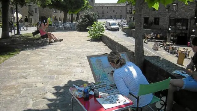 Un concurso de acuarelistas en el que una de las participantes pinta la torre y la plaza Mayor de Aínsa.
