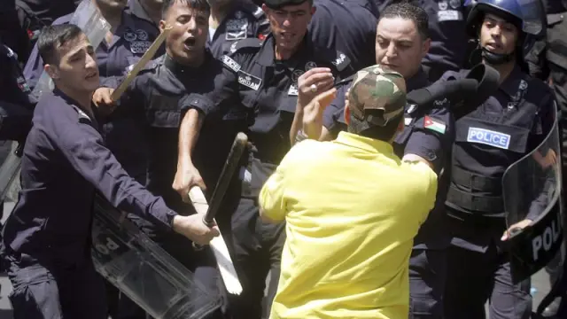 Varios policías golpean a un manifestante durante las protestas.