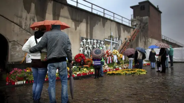 Varias personas muestran sus respetos por las víctimas de la tragedia de la 'Loveparade' en su primer aniversario.