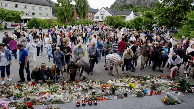 Ciudadanos noruegos dejando velas y flores en homenaje a las víctimas