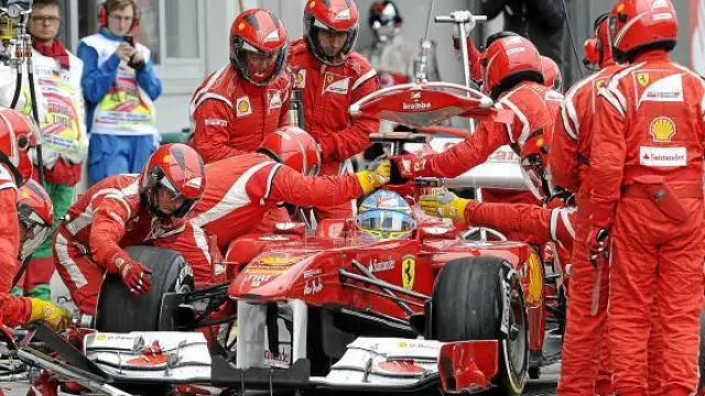 Los mecánicos de Ferrari trabajan en el coche de Alonso, durante el pasado Gran Premio de Alemania.