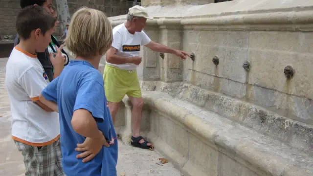 Un anciano explica a las generaciones más jóvenes la leyenda de la fuente en Alcañiz.
