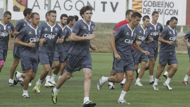Los futbolistas del Huesca realizan carrera continua durante el entrenamiento de la tarde en el Instituto Montearagón.