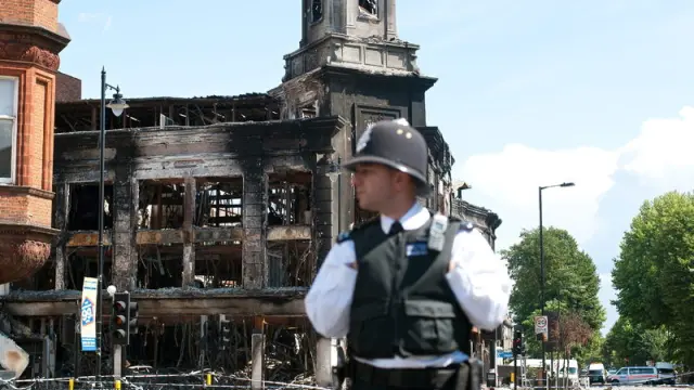 Un agente vigila el edificio quemado en madrugada del domingo
