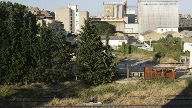 Vista de la fábrica de Harinas Porta desde la calle Almudévar, donde todavía quedan restos de la antigua vía del tren.