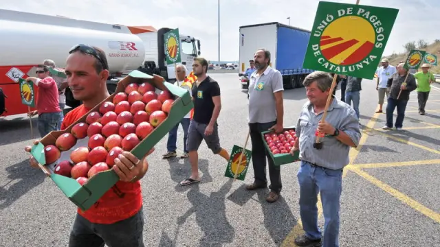 Un grupo de agricultores repartiendo fruta en la frontera de la Junquera