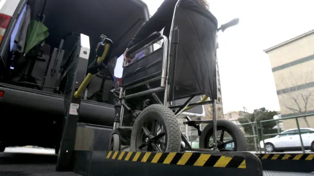 Imagen de archivo de una persona discapacitada accediendo a un vehículo adaptado