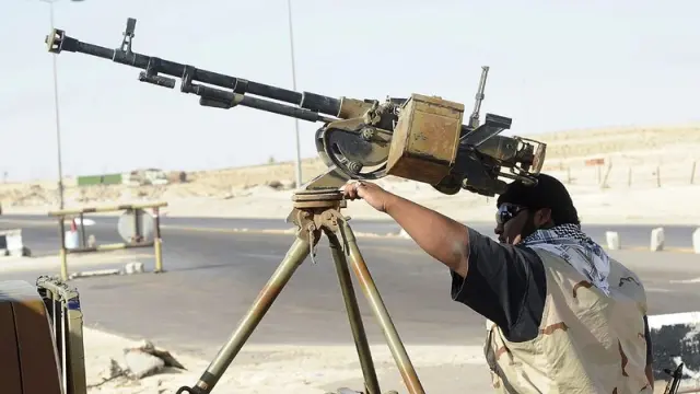 Fotografía del 18 de agosto, muestra a un rebelde libio preparando un arma a las puertas de Ajdabiya