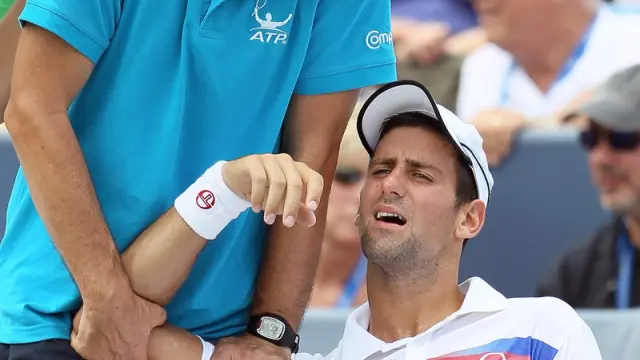 Novak Djokovic recibe las asistencias de su fisioterapeuta.