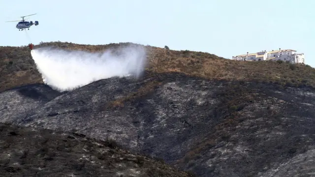 Un helicoptero trabaja en las labores de extinción del incendio de Mijas