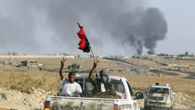 Rebeldes libios saludan desde un vehículo