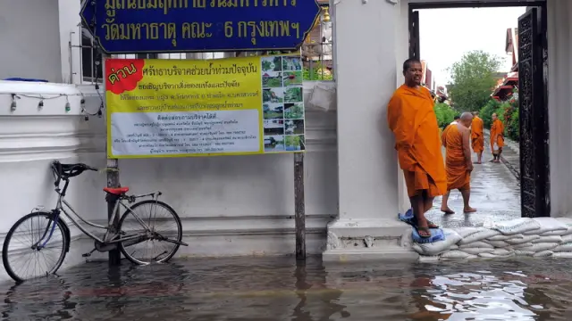 Un monje observa las inundaciones en el exterior de una Pagoda
