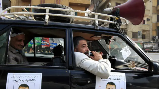 Un hombre pide el voto para un candidato a través de la megafonía instalada en un coche