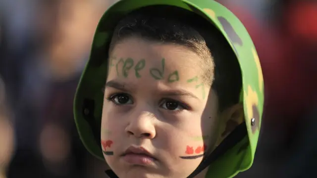 Un niño sirio con la palabra libertad pintada en la cara