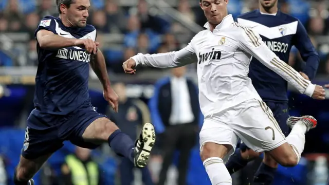 El portugués Cristiano Ronaldo se dispone a hacerse con el balón ante el centrocampista francés del Málaga.