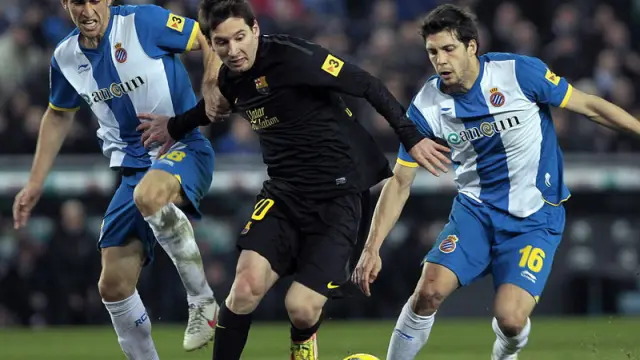El argentino, Leo Messi, lleva el balón, ante los jugadores del Espanyol.