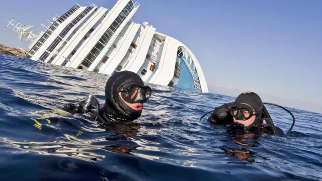 Buceadores de los Carabiniari italianos en el agua cerca del crucero Costa Concordia