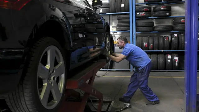 Un mecánico cambia las ruedas de un vehículo