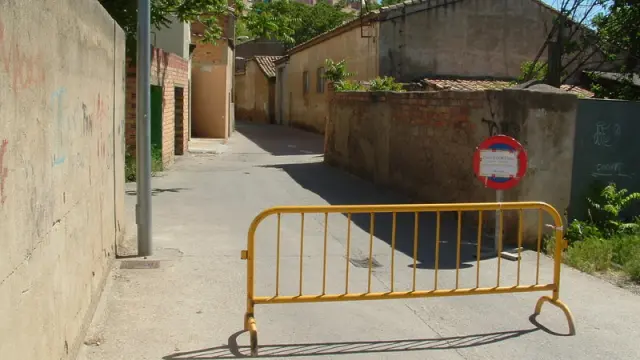 La entrada a la calle desde Ronda del Isuela presenta una valla de obra y una señal que informa del cierre al tráfico