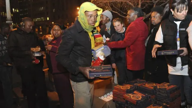 Varias personas entregan mantas y alimentos a gente sin hogar para celebrar el Día Internacional de Mandela.