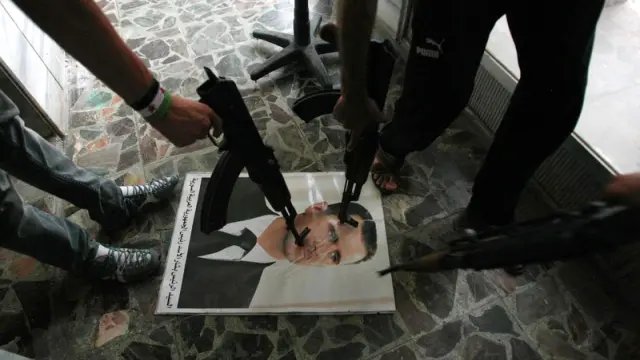 Opositores sirios apuntan a un retrato de Al Asad