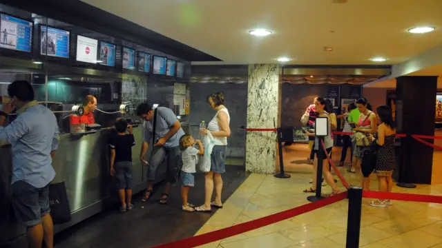 Varias personas hacen fila en la taquilla de un cine zaragozano