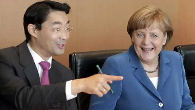 Angela Merkel conversa con el ministro alemán Philipp Rösler.